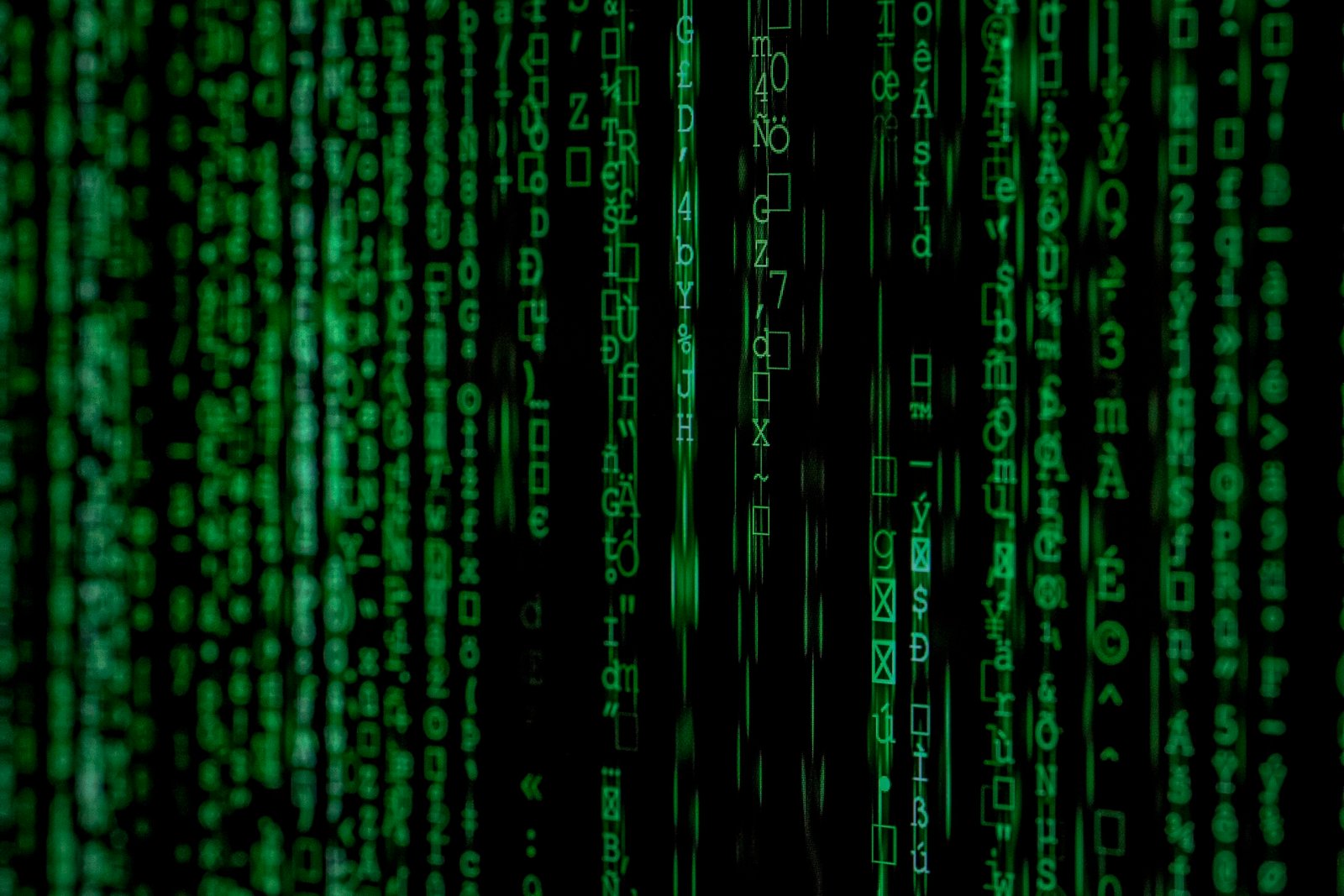 Ransomware code on dark screen with red warning symbols